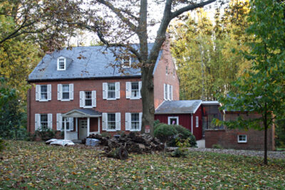 Red brick mansion with white shutters and two dormers